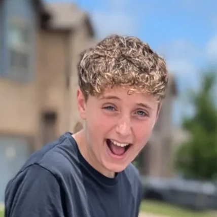 Service provider rolling trash cans to the curb at dusk